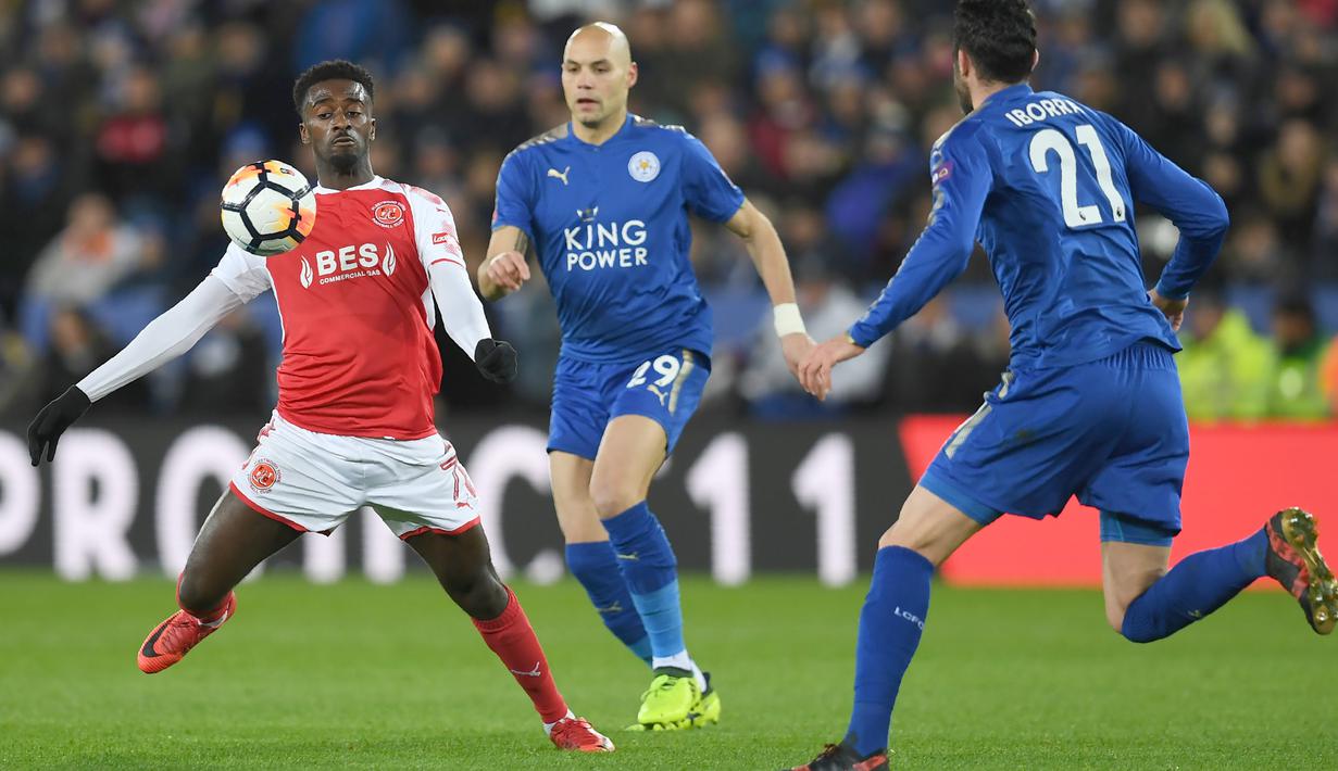 Aksi pemain Fleetwood Town, Jordy Hiwula (kiri) berusaha melewati dua pemain Leicester City pada babak ketiga Piala FA di King Power Stadium, Leicester, (16/1/2018). Leicester City menang 2-0. (AFP/Paul Ellis)