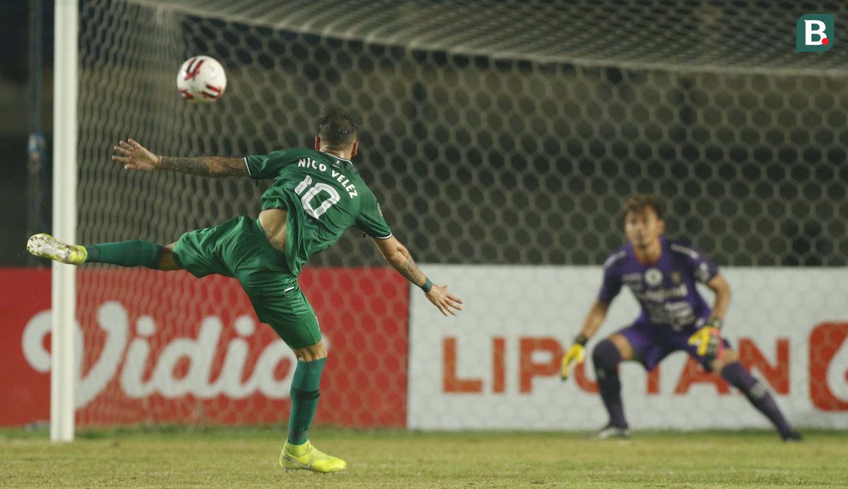 Striker PS Sleman Velez Nicolas Leandro (kiri) menendang bola ke gawang Bali United yang dikawal Wawan Hendrawan dalam laga perempatfinal Piala Menpora 2021 di Stadion Si Jalak Harupat, Bandung, Senin (12/4/2021). (Bola.com/Ikhwan Yanuar)