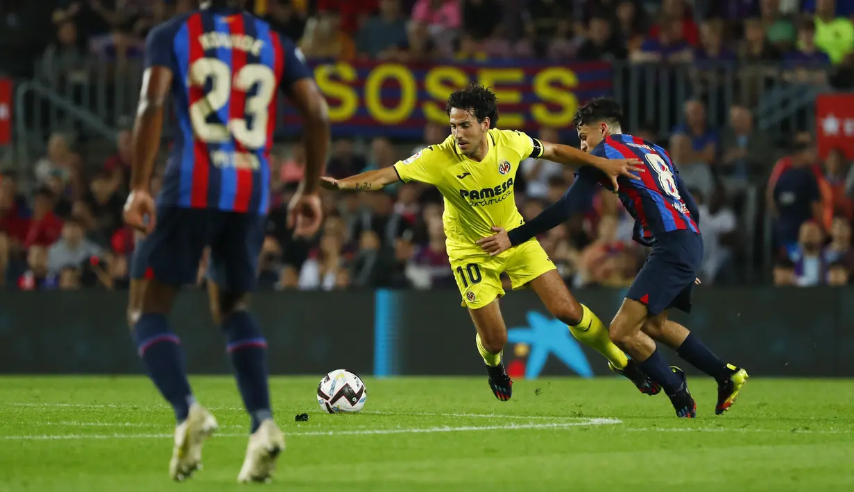 Gelandang Real Madrid, Dani Parejo berusaha melewati gelandang Barcelona, Pedri selama pertandingan lanjutan La Liga Spanyol di stadion Camp Nou di Barcelona, Spanyol, Jumat (21/10/2022). Barcelona menang atas Villareal 3-0. (AP Photo/Joan Monfort)