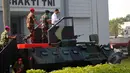 Presiden Joko Widodo saat menaiki Panser Anoa untuk menghadiri upacara pengangkatan dirinya sebagai warga kehormatan pasukan khusus TNI, Kamis (16/4/2015). (Liputan6.com/Yoppy Renato)