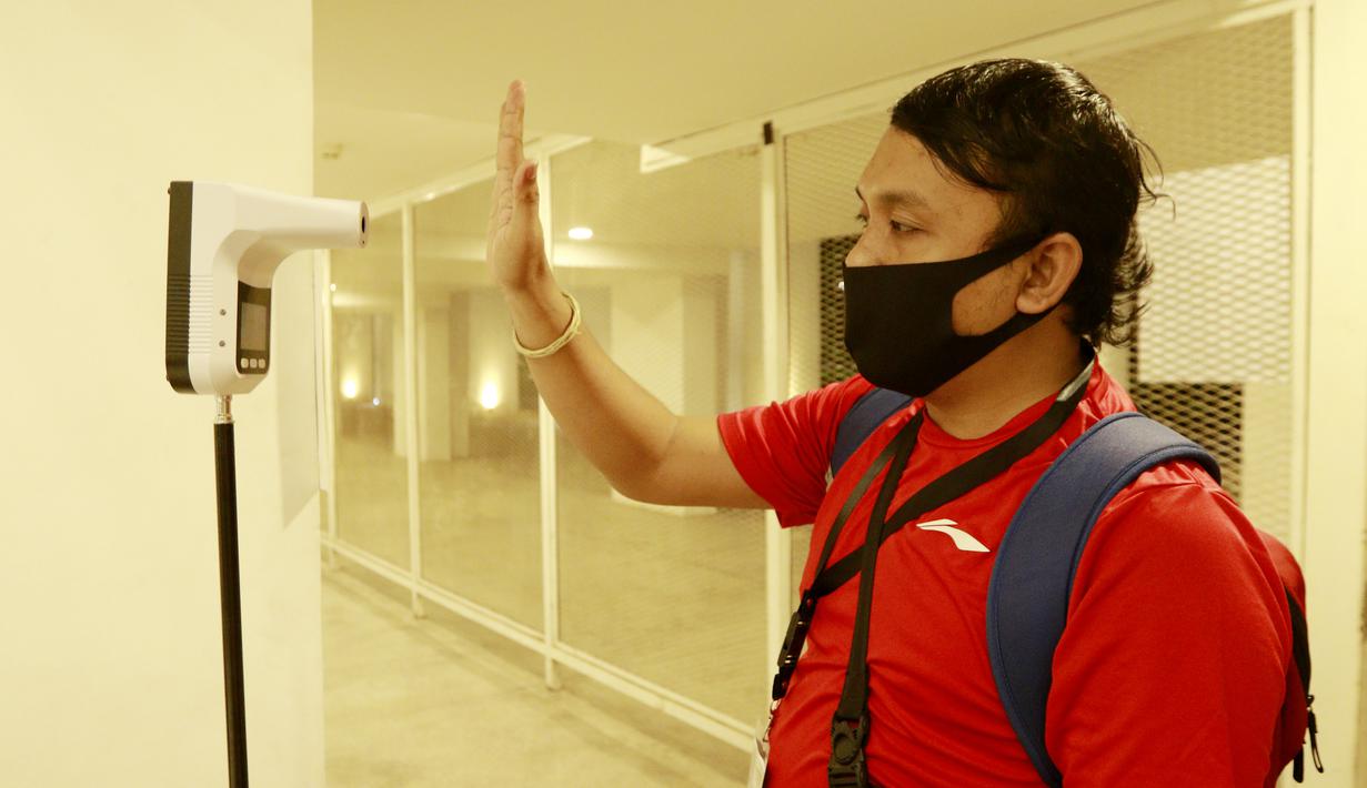 Seorang wartawan melakukan pengecekan suhu tubuh sebelum memasuki Stadion Madya untuk meliput pertandingan antara Timnas Indonesia melawan Persikabo 1973. (Bola.com/ M Iqbal Ichsan)