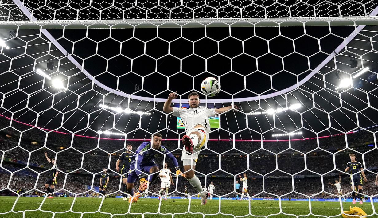 Pemain Jerman, Niclas Fullkrug (kanan) berusaha mencetak gol ke gawang Skotlandia pada laga pembuka Grup A Euro 2024 di Allianz Arena, Munchen, Jerman, Sabtu (15/06/2024) WIB. (AP Photo/Antonio Calanni)