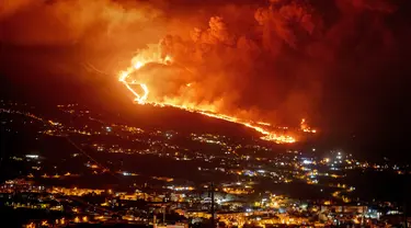 Lava mengalir saat gunung berapi terus meletus di pulau Canary La Palma, Spanyol (30/11/2021). Beberapa lubang vulkanik baru dibuka di La Palma, melepaskan lava baru yang mengalir cepat menuruni punggung bukit dan akan berdampak pada tanah, infrastruktur, dan rumah. (AP/Emilio Morenatti)