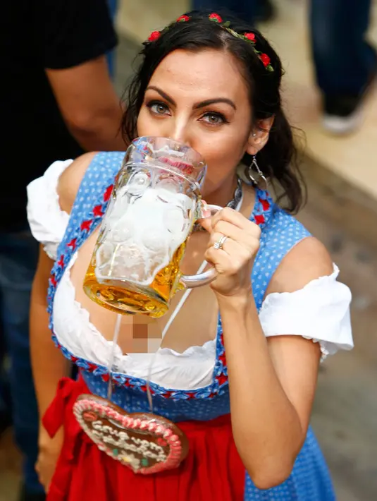 Seorang wanita menikmati bir saat menghadiri pembukaan Oktoberfest ke-183 di Munich, Jerman, Sabtu (17/9). (REUTERS/Michaela Rehle)