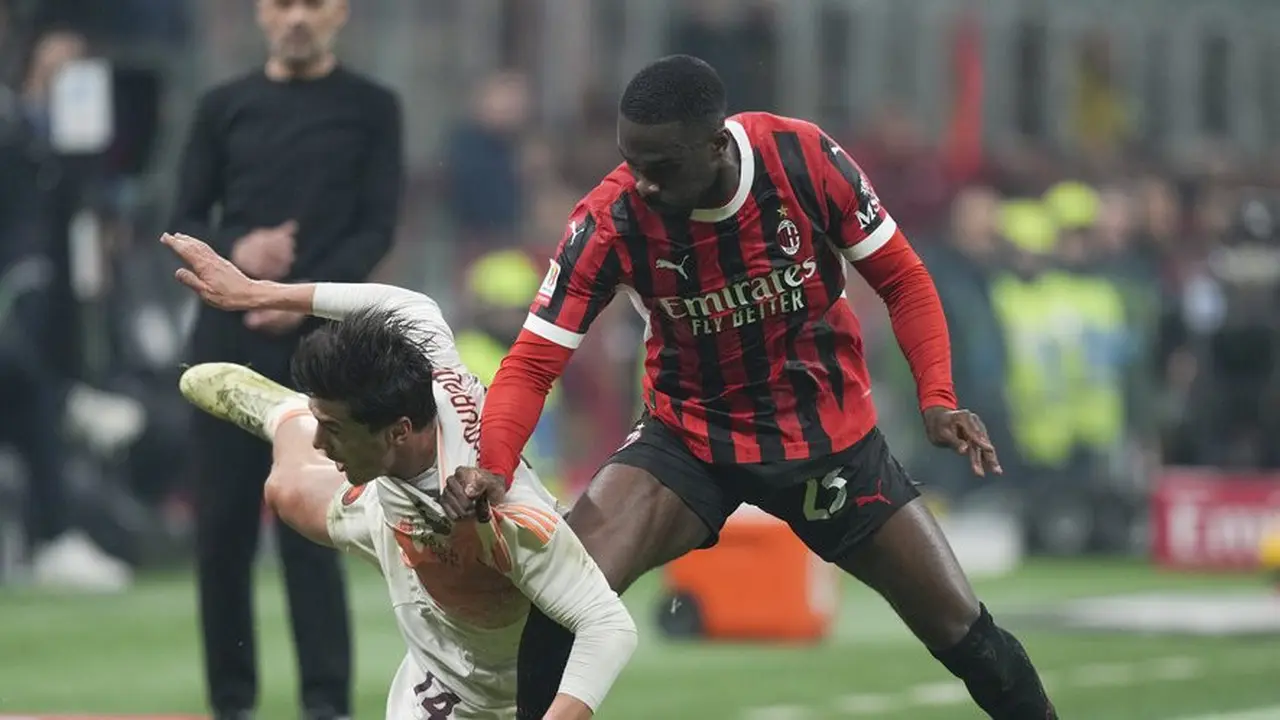 Fikayo Tomori berduel dengan Eldor Shomurodov di laga perempat final Coppa Italia 2024-2025 antara AC Milan vs AS Roma. (c) AP Photo/Antonio Calanni
