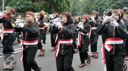 Peserta Kirab Budaya Merah Putih memainkan terompet, Bogor, Jawa Barat, Minggu (13/11). Acara ini bertujuan untuk memperkenalkan budaya bangsa kepada anak-anak muda dan sekaligus mempromosikan wisata serta kuliner Bogor. (Liputan6.com/Yoppy Renato)