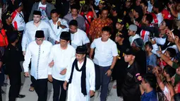Mantan Wali Kota Solo itu (tengah) didampingi pimpinan ponpes Al-Baghdadi, K.H. Junaedi Al-Baghdadi (kanan) berjalan menuju tempat acara doa bersama, Karawang, Jumat (4/7/14). (Liputan6.com/Andrian M Tunay)