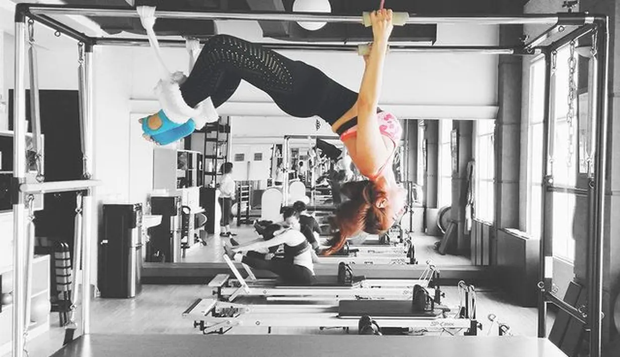 Melakoni pilates layaknya profesional, Astrid Tiar mengenakan sport bra bermotif berwarna pink dipadukan dengan legging hitam dengan aksen.  (instagram/astridtiar127)