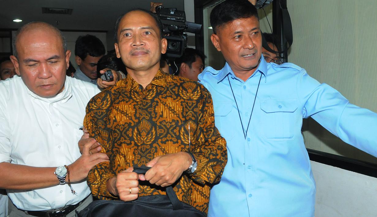 Budi Mulya tampak dikawal usai menjalani sidang perdana di Pengadilan Tipikor, Jakarta (Liputan6.com/Herman Zakharia)
