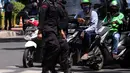 Dua polisi menyeberang jalan saat berjaga di sekitar Pengadilan Negeri Jakarta Selatan, Senin (4/1/2021). Pengamanan ratusan aparat kepolisian dilakukan untuk mengantisipasi pergerakan masa pada saat sidang praperadilan Rizieq Shihab. (Liputan6.com/Angga Yuniar)