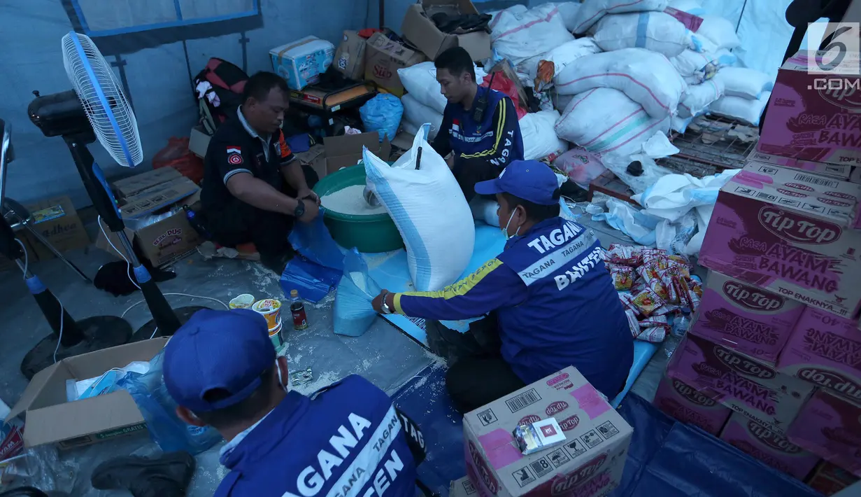 Relawan Tagana memasukan beras dan mie instan untuk Warga korban gempa dan tsunami Palu di kantor Dinas Sosial, Palu, Sulawesi Tengah, Minggu (7/10). Warga antre sejak pagi untuk mendapatkan bantuan yang disalurkan dari Dinsos. (Liputan6.com/Fery Pradolo)