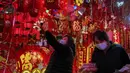 Seorang wanita memilih dekorasi Tahun Baru Imlek di sebuah mal di Beijing (16/1/2022). Beijing telah melaporkan infeksi omicron lokal pertamanya, beberapa minggu sebelum Olimpiade Musim Dingin akan dimulai. (AP Photo/Andy Wong)