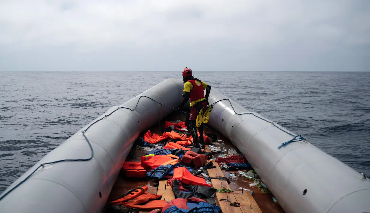 Seorang anggota LSM Proactiva Open Arms Spanyol memeriksa perahu karet yang membawa pengungsi dan imigran tujuan Eropa di utara pantai Libya, Minggu (6/5). (AP Photo/Felipe Dana)