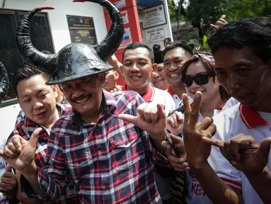 Cawagub DKI Jakarta, Djarot Saiful Hidayat menggenakan topi banteng saat kunjungan ke Jalan Ali Sadikin di Kelurahan Papanggo, Jakarta Utara, Rabu (23/11). (Liputan6.com/Faizal Fanani)