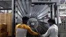 Para pekerja mengunci pintu ruang sterilisasi di pabrik Jarum Suntik Hindustan di Faridabad (2/9/2020). Produsen jarum suntik terbesar di India meningkatkan produksinya untuk menghasilkan satu miliar unit. (AFP/Sajjad Hussain)