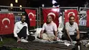 Orang-orang duduk di luar Hagia Sophia era Bizantium, di distrik bersejarah Sultanahmet di Istanbul, Kamis, 23 Juli 2020, sehari sebelum sholat Muslim pertama di monumen tengara dalam 86 tahun setelah konversi kembali menjadi masjid. (AP Photo/Omer Kuscu)