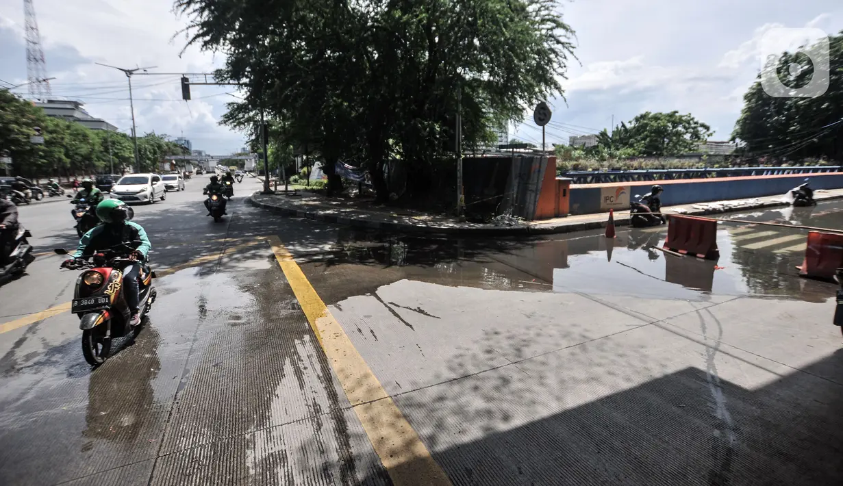 Pengendara sepeda motor melintas dekat lokasi banjir yang menggenangi Jalan RE Martadinata, Ancol, Jakarta, Selasa (9/11/2021). Banjir yang terjadi sejak 4 November 2021 masih menggenangi Jalan RE Martadinata, tepatnya di seberang Aston Mediterania. (merdeka.com/Iqbal S. Nugroho)