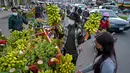 Seorang wanita membeli pisang di sepanjang jalan di Phnom Penh 13/10/2021). Tiga spesies pisang  kuning, gula dan hijau semuanya banyak ditanam di Kamboja. (AFP/Tang Chhin Sothy)