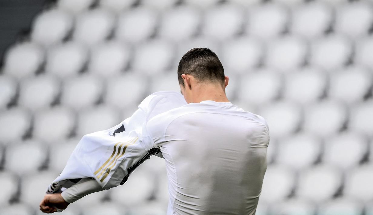 Striker Juventus, Cristiano Ronaldo melepas jersey untuk diberikan kepada seorang ball boy usai berakhirnya laga melawan Genoa dalam lanjutan Liga Italia 2020/2021 pekan ke-30 di Allianz Stadium, Turin, Minggu (11/4/2021). Juventus menang 3-1 atas Genoa. (AFP/Marco Bertorello)