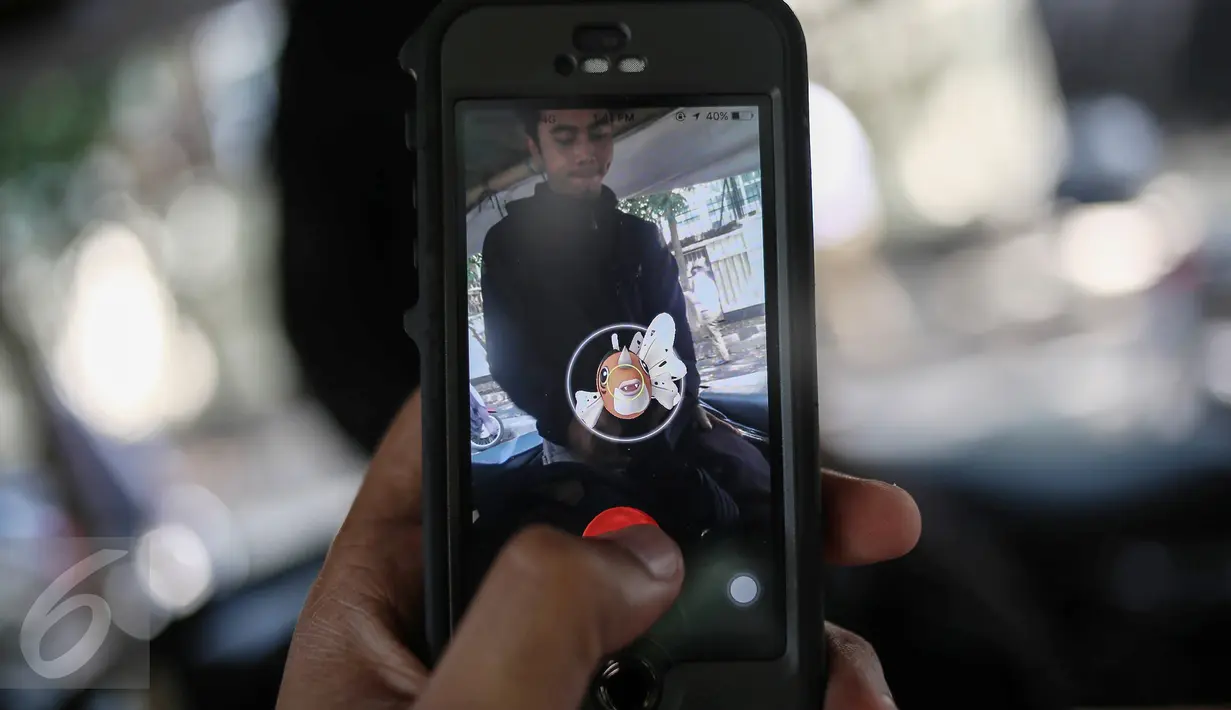 Karakter Pokemon terlihat di dekat seorang pria pada layar smartphone pemain augmented reality game Pokemon Go di Jakarta, Kamis (14/7). Pokemon Go sedang di puncak ketenaran meski baru diluncurkan di beberapa negara. (Liputan6.com/Faizal Fanani)