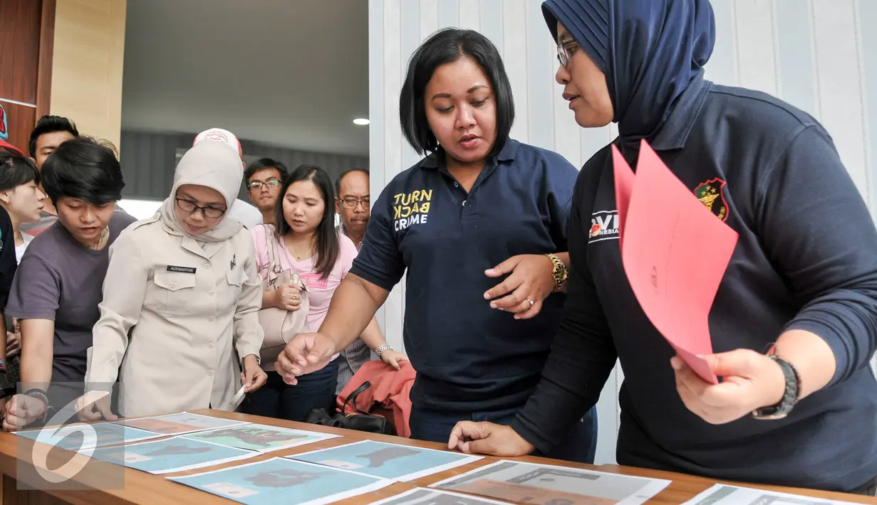 Petugas mengidentifikasi hasil tes postmortem dan antemortem di RS Polri, Jakarta, Selasa (3/1). Akibat sulitnya diidentifikasi para keluarga korban harus membawa dokumen dan berkas yang mencirikan keluarnya. (Liputan6.com/Yoppy Renato)
