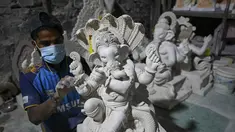 Perajin mengerjakan patung dewa Hindu berkepala gajah Lord Ganesha di sebuah lokakarya menjelang festival Ganesh Chaturthi di Mumbai (12/8/2021). Festival Ganesh Chaturthi adalah perayaan kelahiran Ganesha, dewa kebijaksanaan, kemakmuran, dan keberuntungan Hindu. (AFP/Punit Paranjpe)