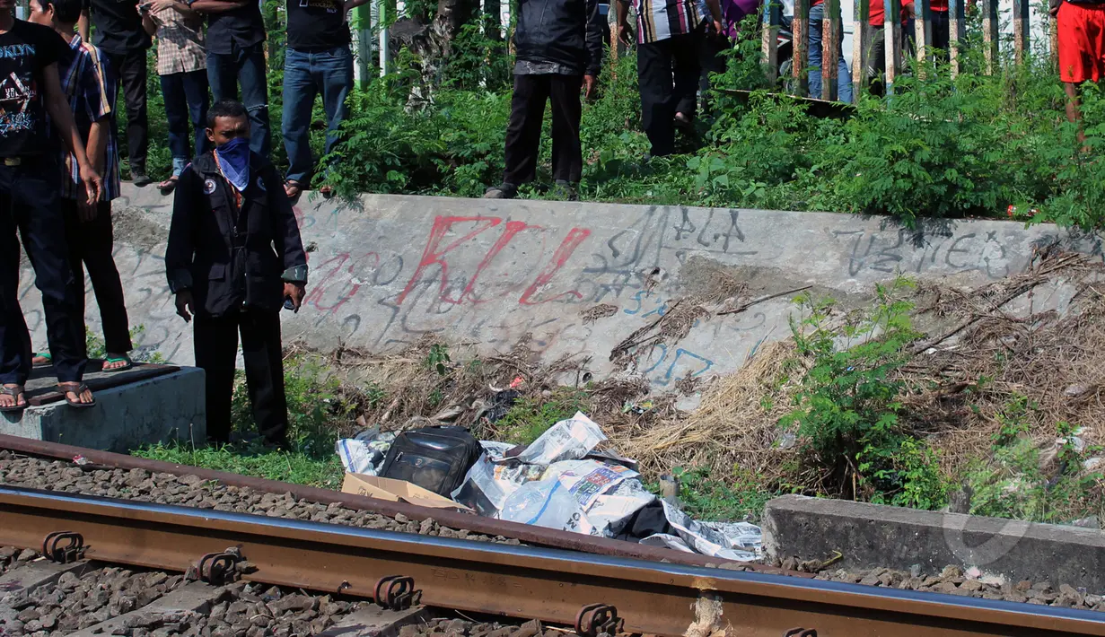 Seorang pria tewas tertabrak kereta api di Palmerah, Jakarta, Jumat, (8/5/2015). Puluhan warga tampak melihat jenazah korban yang tergeletak di pinggir rel. (Liputan6.com/JohanTallo)
