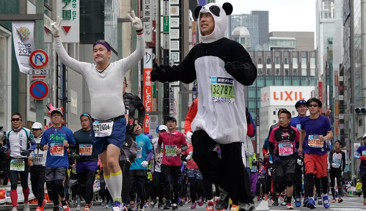Peserta berkostum panda melintas di distrik perbelanjaan Ginza saat ambil bagian dalam Tokyo Marathon 2018 , Minggu (25/2). Tokyo Marathon merupakan ajang bergengsi lari kelas dunia yang diikuti pelari dari berbagai belahan negara. (AP/Shizuo Kambayashi)