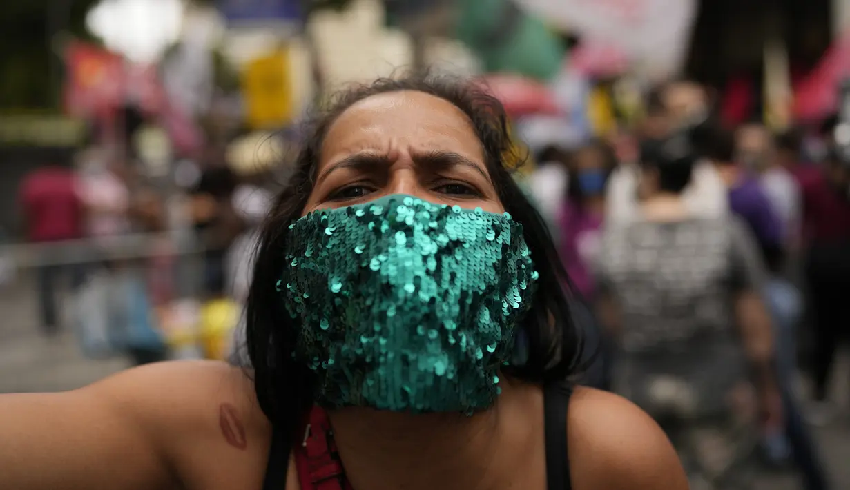 Seorang wanita menghadiri protes penanganan Presiden Brasil Jair Bolsonaro terhadap pandemi COVID-19 pada Hari Kemerdekaan di Rio de Janeiro, Selasa (7/9/2021). Ribuan orang yang turun ke jalan terbagi dalam dua kubu yaitu pendudukung serta penentang Bolsonaro. (AP Photo/Silvia Izquierdo)