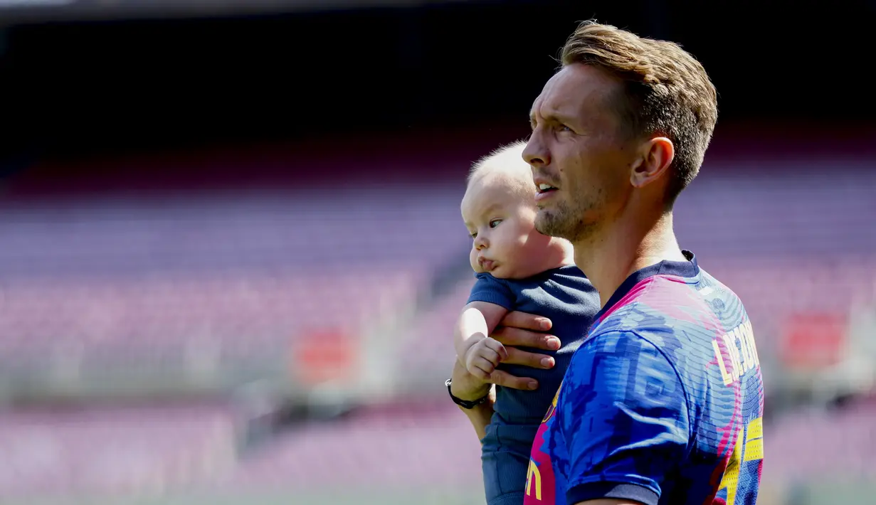 Striker Belanda Luuk De Jong dan putranya berpose untuk media selama perkenalan resminya setelah menandatangani kontrak dengan FC Barcelona di Barcelona, Spanyol, Kamis (9/9/2021). De Jong merupakan pemain yang dimiliki Sevilla sebelum bergabung bersama Barcelona. (AP Photo/Joan Monfort)