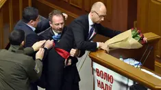 Seorang anggota parlemen bernama Oleg Barna tampak menyeret PM Arseny Yatsenyuk (kanan) dari podium saat membacakan laporan tahunan kinerja Pemerintah Ukraina di Majelis Tinggi Parlemen Ukraina, 11 Desember 2015. (Sergei SUPINSKY/AFP)