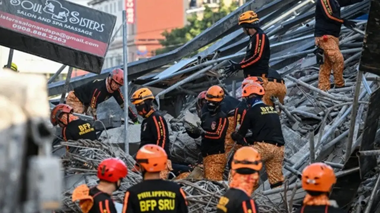 Tim penyelamat dari Biro Perlindungan Kebakaran membersihkan puing-puing sambil melanjutkan pencarian korban di lokasi gedung runtuh di Kota Angeles, Filipina, pada 24 Mei 2026.