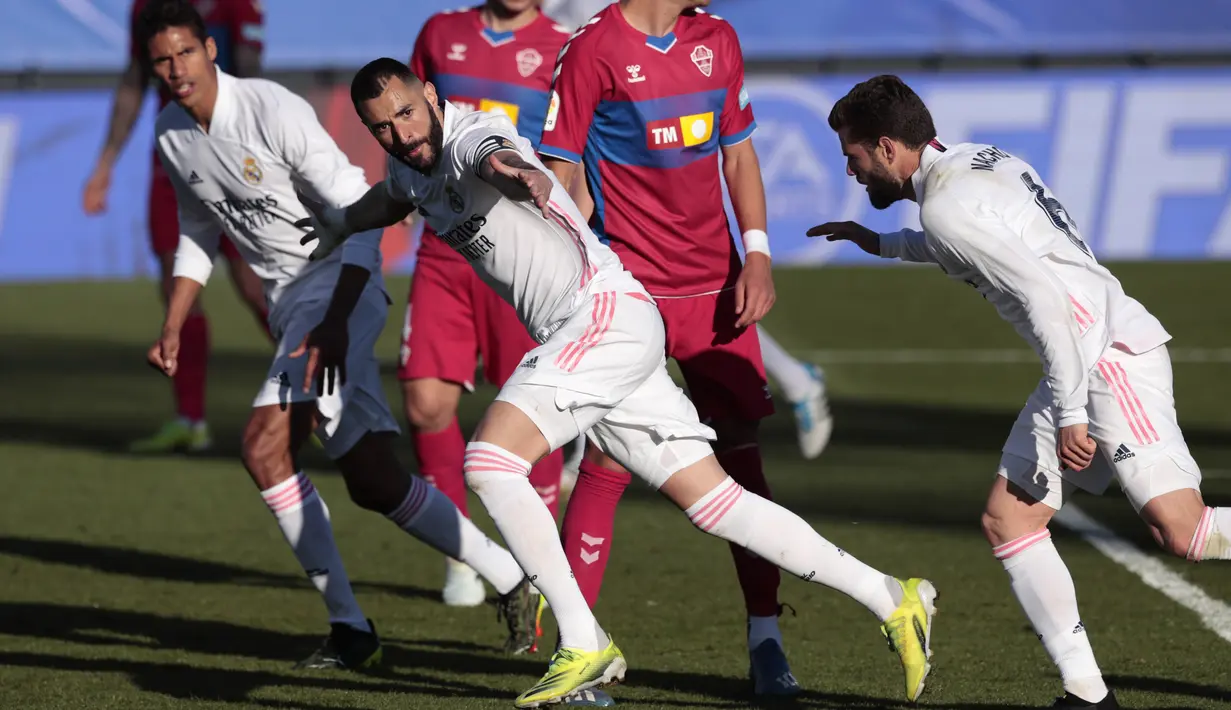 Striker Real Madrid, Karim Benzema, melakukan selebrasi usai mencetak gol ke gawang Elche pada laga Liga Spanyol di Stadion Alfredo di Stefano, Sabtu (13/3/2021). Real Madrid menang dengan skor 2-1. (AP/Bernat Armangue)