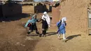 Anak-anak sekolah pengungsi Afghanistan berjalan setelah mengikuti kelas di sekolah darurat di pinggiran Islamabad, Pakistan, Rabu (29/12/2021). (AP Photo/Rahmat Gul)