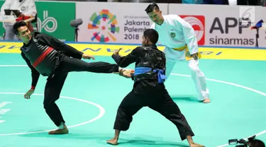 Pesilat Indonesia, Komang Harik Adiputra (kanan) bertanding melawan pesilat Timor Leste, David No-Ano Ximenes dalam kelas 65-70 kg Putra Asian Games 2018 di Padepokan Pencak Silat TMII, Jakarta, Kamis (23/8). Komang unggul 5-0. (Liputan6.com/Fery Pradolo)