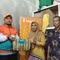 Business Coach BTPN Syariah area Riau, Fauzan Ridha memberikan cinderamata kepada UMKM Ultra Mikro kerupuk Kuansing di Kelurahan Air Dingin, Kota Pekanbaru. (Liputan6.com/Dicky Agung Prihanto)