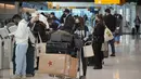 Wisatawan mengantre di kios check-in United American Airlines di terminal Bandara Internasional Denver di Denver (26/12/2021). Maskapai menunda ratusan penerbangan pada Minggu (26/12), karena alasan keterbatasan petugas terkait Covid-19 menambah masalah perjalanan usai Natal. (AP Photo/David Zalubow