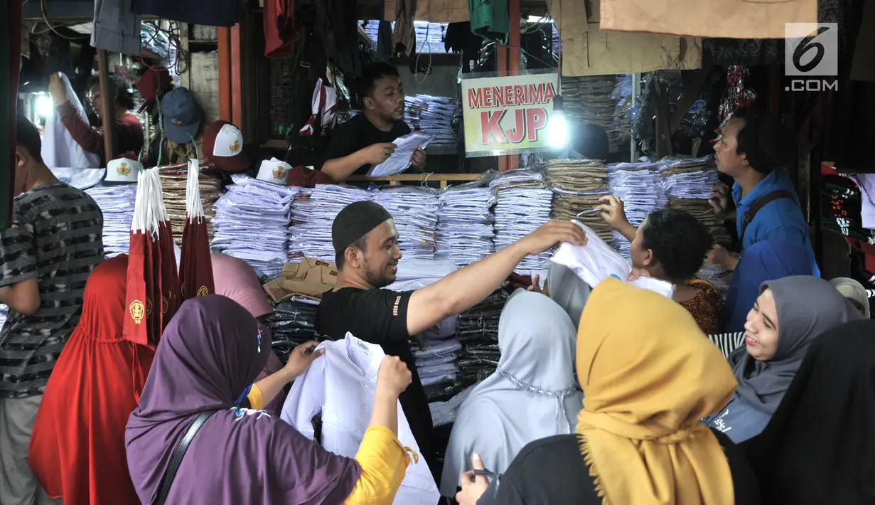 Pedagang melayani para orangtua yang mencari seragam sekolah di Pasar Jatinegara, Jakarta, Minggu (14/7/2019). Jelang tahun ajaran baru, Pasar Jatinegara ramai didatangi para orangtua yang mencari seragam sekolah untuk anaknya. (merdeka.com/Iqbal Nugroho)