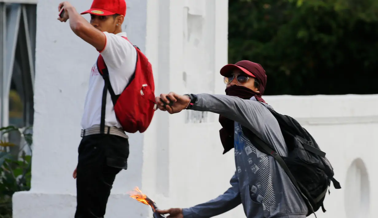 Demonstran antipemerintah melemparkan bom molotov ke arah Pengawal Nasional Bolivarian Venezuela saat demonstrasi menuntut pengunduran diri Presiden Nicolas Maduro di Caracas, Venezuela, Sabtu (2/2). (AP Photo/Fernando Llano)