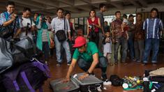 Bek kiri Timnas Indonesia, Benny Wahyudi, membongkar tas saat tiba di Bandara Soekarno-Hatta, Banten, Sabtu (26/11/2016). Pemain Arema Cronus ini kembali ke tanah air usai berlaga pada Piala AFF 2016. (Bola.com/Vitalis Yogi Trisna)