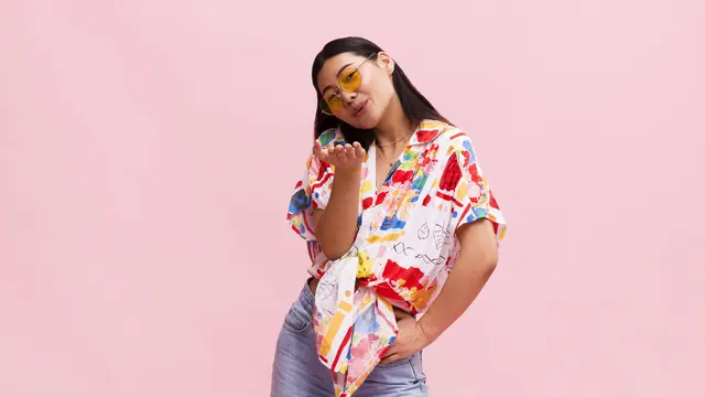 Seorang perempuan mengenakan kemeja berwarna-warni sedang berpose memberikan flying kiss (Foto Dok: Freepik/freepik)