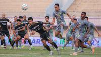 Pemain Persebaya Surabaya, Mohammad Hidayat (tengah kanan) berusaha menghalau bola saat pemain Dewa United, Agung Mannan berusaha mencetak gol pada laga lanjutan BRI Liga 1 2023/2024 antara Dewa United melawan Persebaya Surabaya di Indomilk Arena, Tangerang, Sabtu (30/09/2023). (Bola.com/Bagaskara Lazuardi)