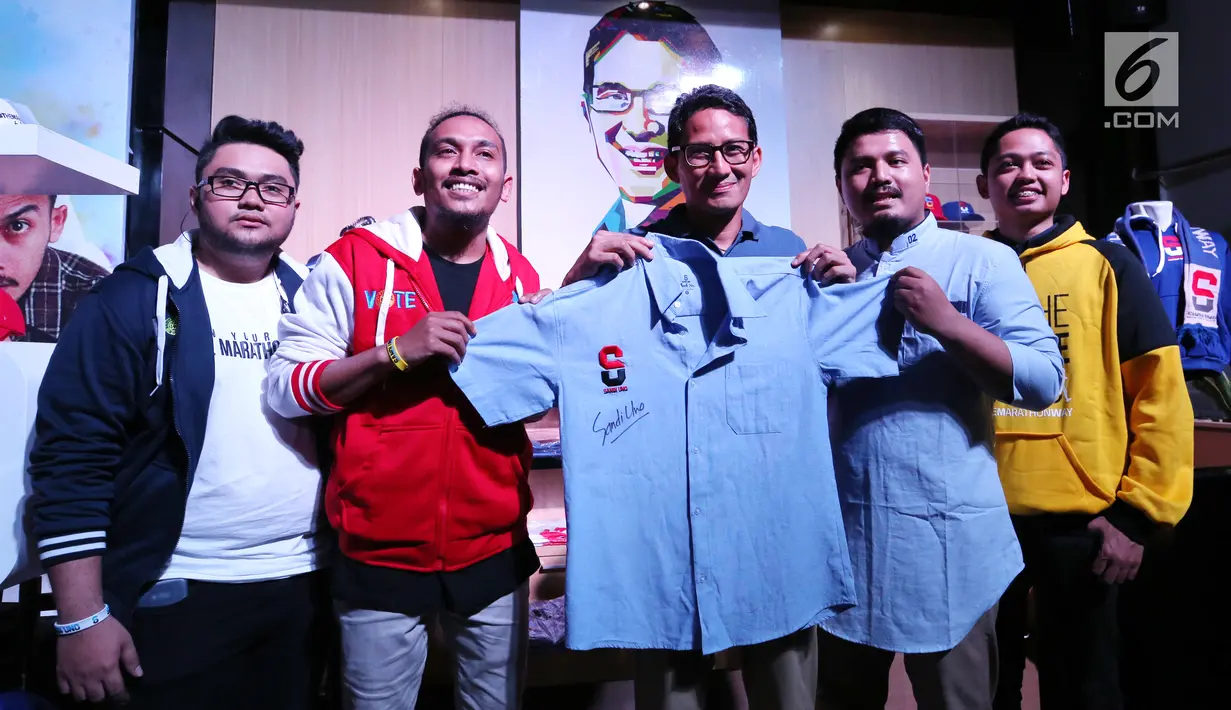 Cawapres nomor urut 02, Sandiaga Uno menunjukkan baju yang telah ditandatangani pada peluncuran merek merchandise Thesandiuno, di Jakarta, Senin (04/2). Merchandise Thesandiuno didesain menyasar pangsa pasar milenial. (Liputan6.com/Fery Pradolo)