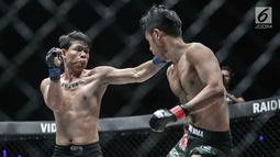 Dua petarung Indonesia, Arnol Batubara (kiri) berusaha meninju petarung  Rizki Umar (kanan) pada partai pertama dalam One Championship di Jakarta, Sabtu (20/1). Rizki Umar menang pada partai pertama One Championship. (Liputan6.com/Faizal Fanani)