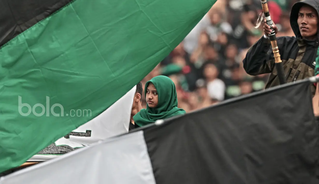 Seorang Suporter wanita menatap serius timnya PSS Sleman berlaga melawan Persipura pada partai pembuka Piala Presiden 2017 di Stadion Maguwoharjo, Sleman, Sabtu (4/2/2017). (Bola.com/Nicklas Hanoatubun)