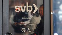 Seorang penjaga keamanan memantau barisan orang yang mencoba mengambil kembali dana mereka di luar kantor Silicon Valley Bank di Santa Clara, California, Senin (13/3/2023). Silicon Valley Bank (SVB) tengah menjadi sorotan karena mengalami kebangkrutan bank terbesar di Amerika Serikat sejak tahun 2008. ( Justin Sullivan/Getty Images/AFP )