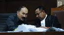 Terdakwa kasus dugaan merintangi penyidikan dugaan korupsi e-KTP, Fredrich Yunadi (kiri) berbincang dengan penasehat hukumnya saat menyimak keterangan saksi di sidang lanjutan di Pengadilan Tipikor, Jakarta, Kamis (15/3). (Liputan6.com/Helmi Fithriansyah)