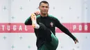 Pemain Portugal, Cristiano Ronaldo melakukan peregangan otot kaki saat sesi latihan perdana jelang Piala Dunia 2018 di base camp mereka di Kratovo, pinggiran Moskow, Rusia, Minggu (10/6). (Francisco LEONG/AFP)