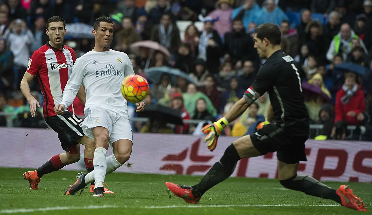  Cristiano Ronaldo saat mencetak gol ke gawang Athletic Bilbao yang dikawal Gorka Iraizoz (kanan) pada lanjtan La Liga Spanyol pekan ke-24 di Stadion Santiago Bernabeu,  Madrid, Sabtu (13/2/2016).  (AFP / Curto De La Torre)