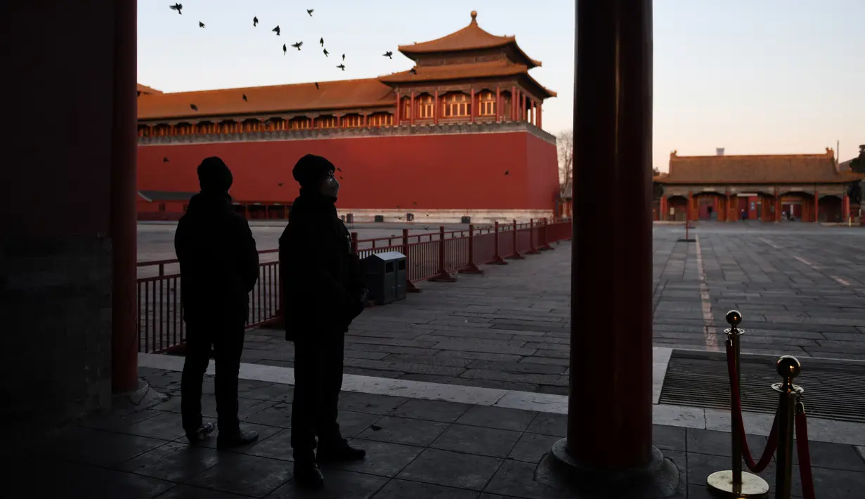 Petugas keamanan berdiri di dekat halaman kosong di luar Kota Terlarang yang ditutup di Beijing, Selasa (4/2/2020). Mencegah korban virus corona bertambah, China menutup  banyak destinasi wisata termasuk Kota Terlarang yang ditutup untuk kunjungan wisatawan sejak 24 Januari 2020. (GREG BAKER/AFP)